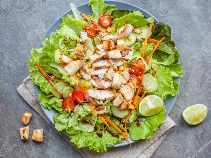 A vibrant grilled chicken salad with mixed greens, juicy grilled chicken, cherry tomatoes, and a lemon vinaigrette.