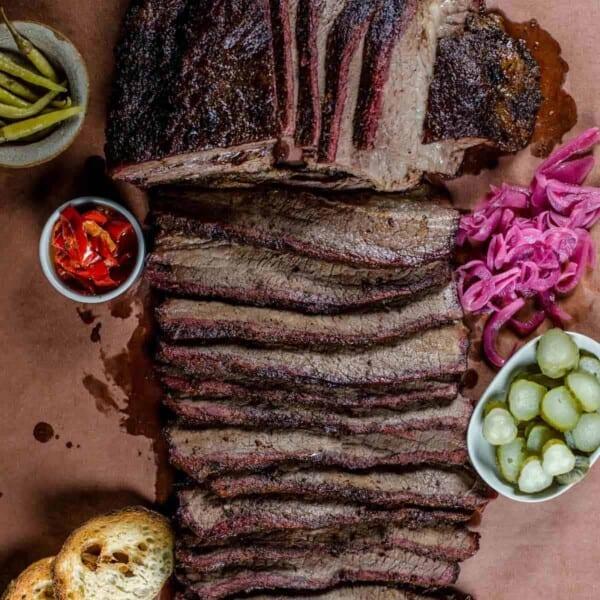 sliced chipotle glazed smoked brisket on cutting board