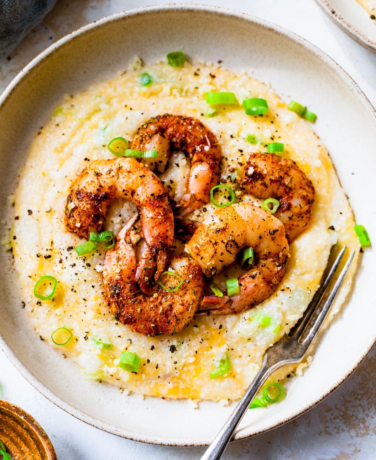 Overhead view of a bowl of Instant Pot Spicy Shrimp and Grits Rice Bowl garnished with green onions.