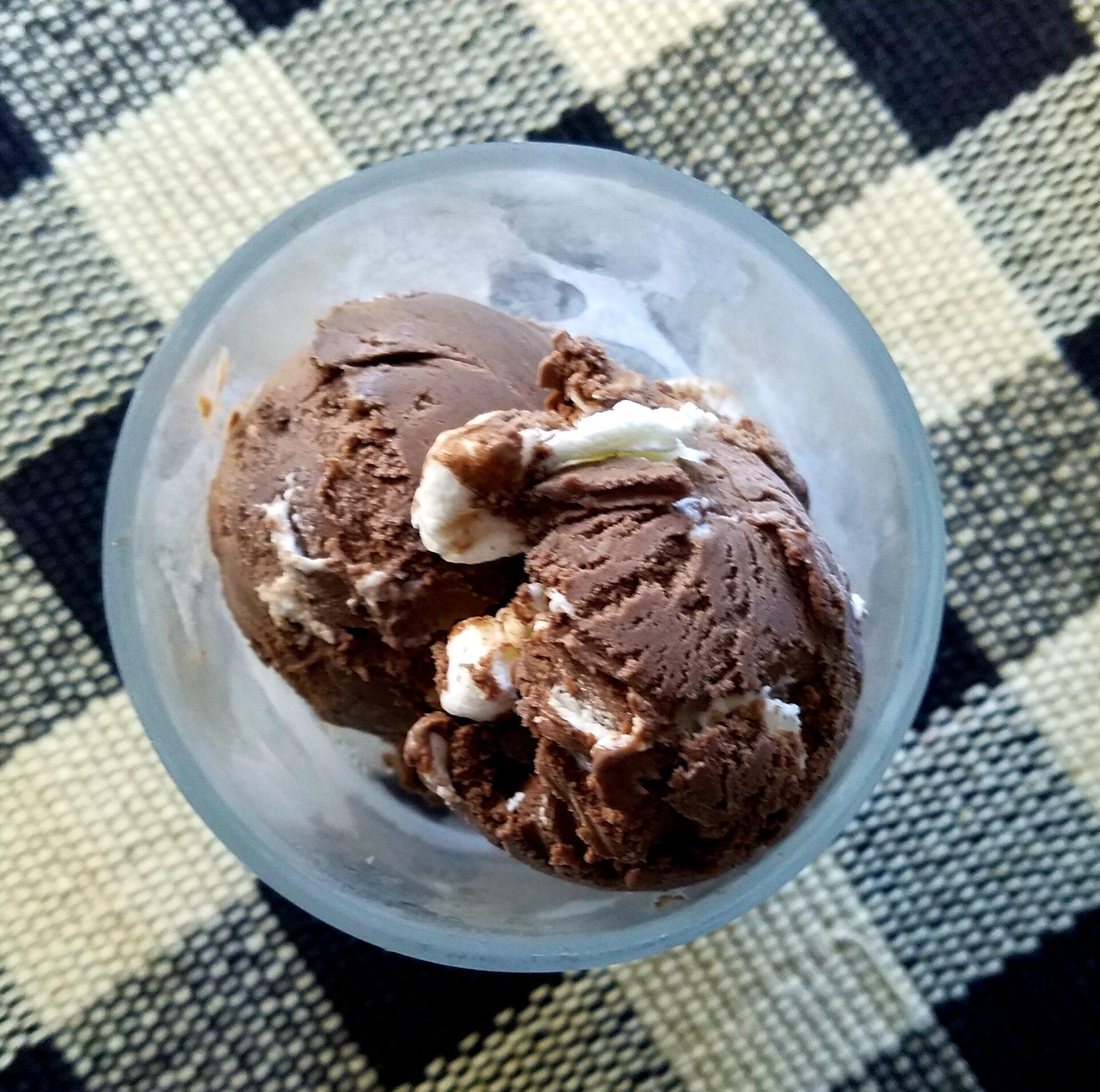 Someone enjoying a bowl of Midnight Chocolate Fudge Ice Cream by a fireplace