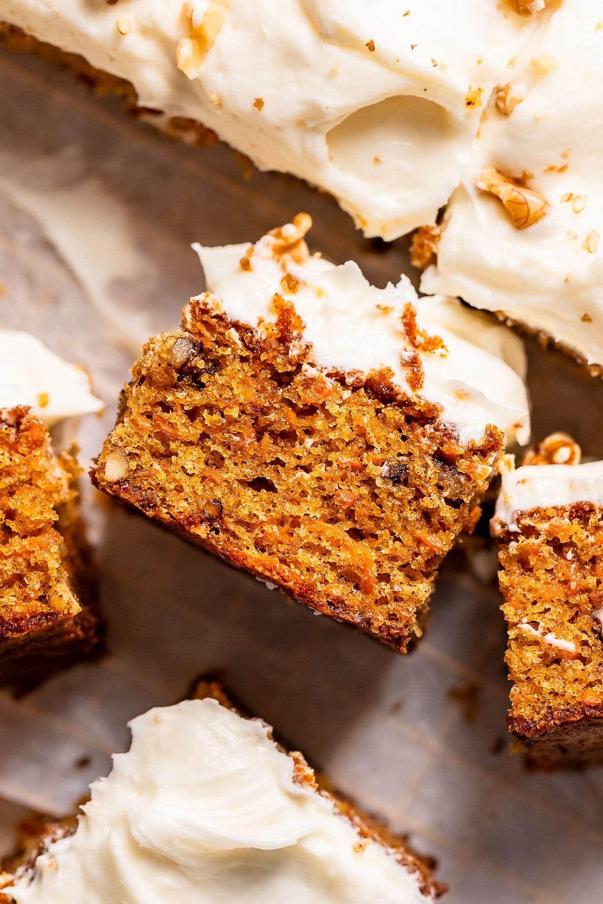 A delicious, moist carrot cake with cream cheese frosting, garnished with carrots and nuts