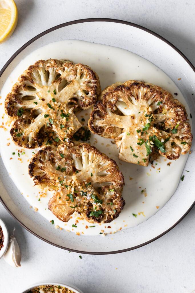 Close-up shot of perfectly roasted cauliflower steaks with a glistening apple cider glaze