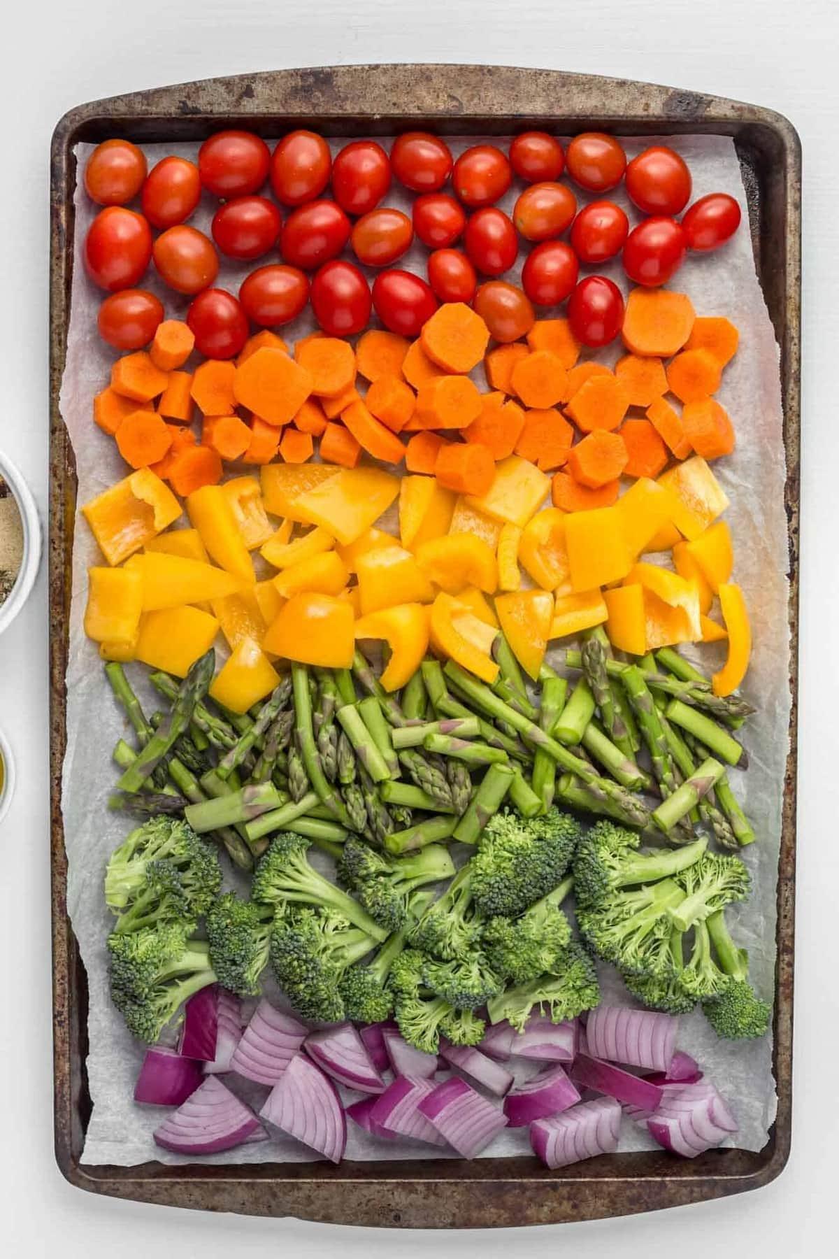 A colorful assortment of roasted vegetable sticks on a baking sheet