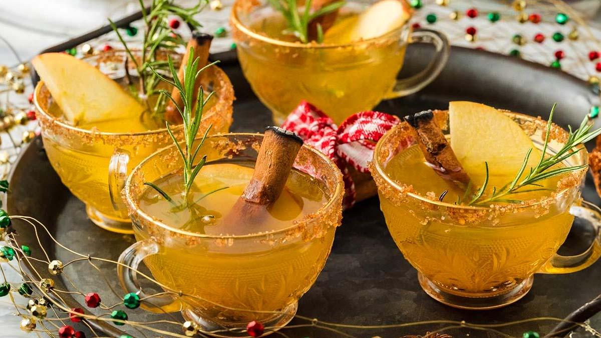 vibrant holiday spiced rum punch in a punch bowl with citrus slices and cinnamon sticks, surrounded by festive decor