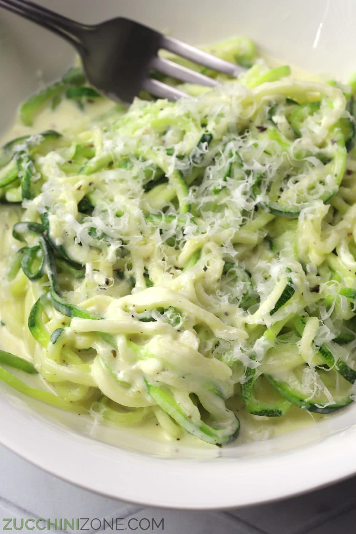 close up of zoodles with alfredo sauce in a pan