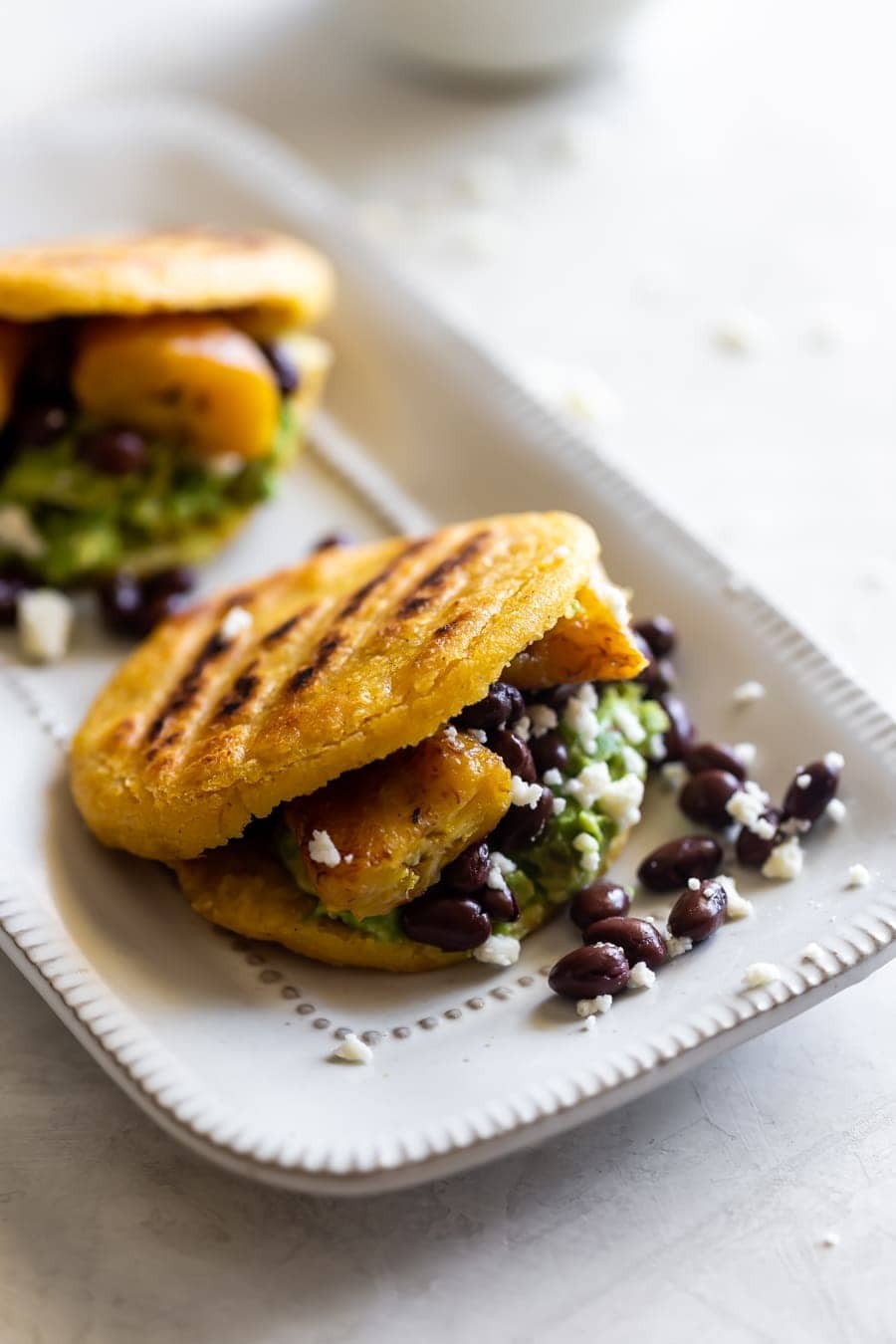 Easter lamb arepas with black beans and plantains plated on a festive table