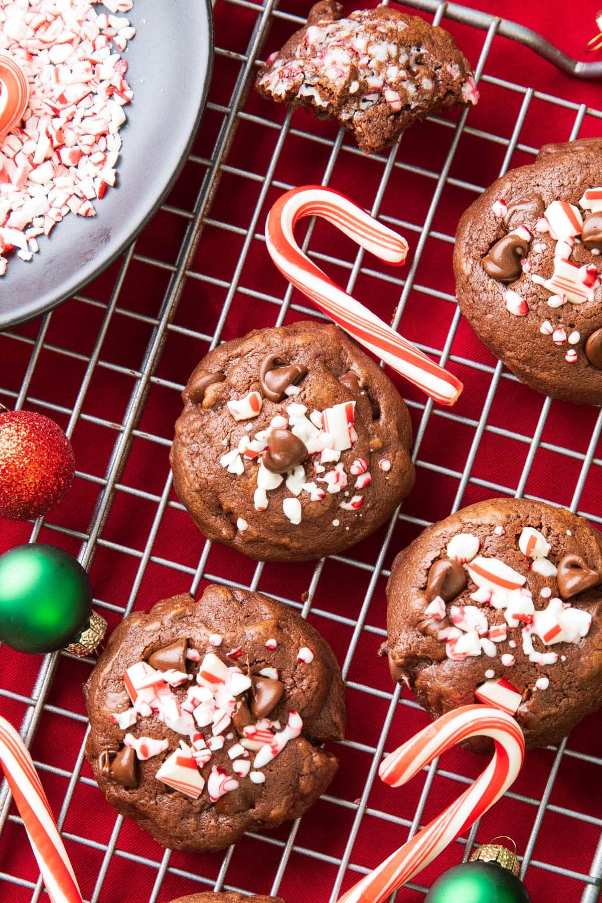 Stack of crunchy cocoa peppermint cookies with crushed candy canes, holiday lights bokeh background