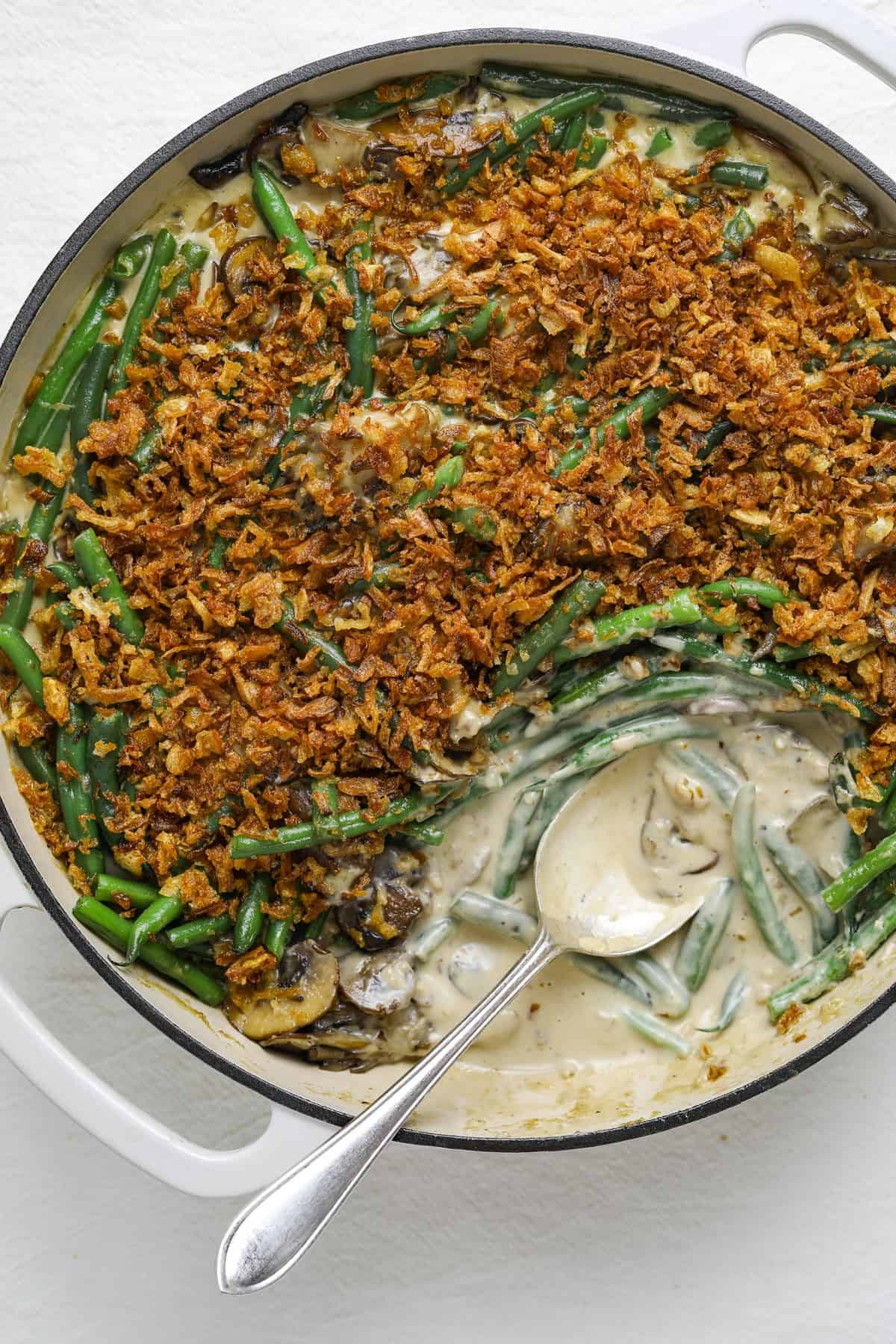 appetizing creamy green bean casserole with golden crispy topping, close-up, warm lighting
