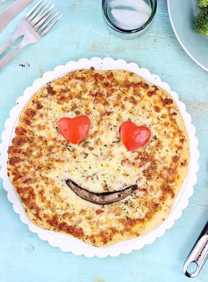 homemade birthday pizza decorated with emoji faces