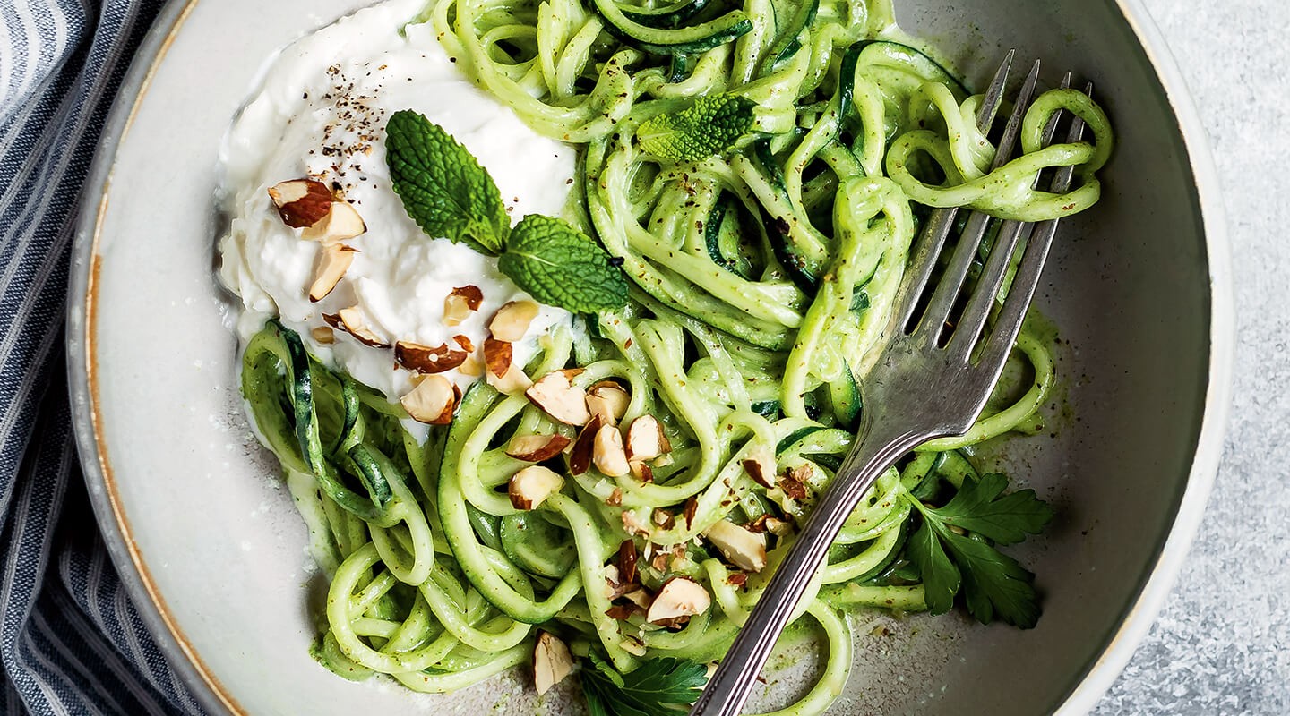 close up shot of zoodles with pesto and burrata