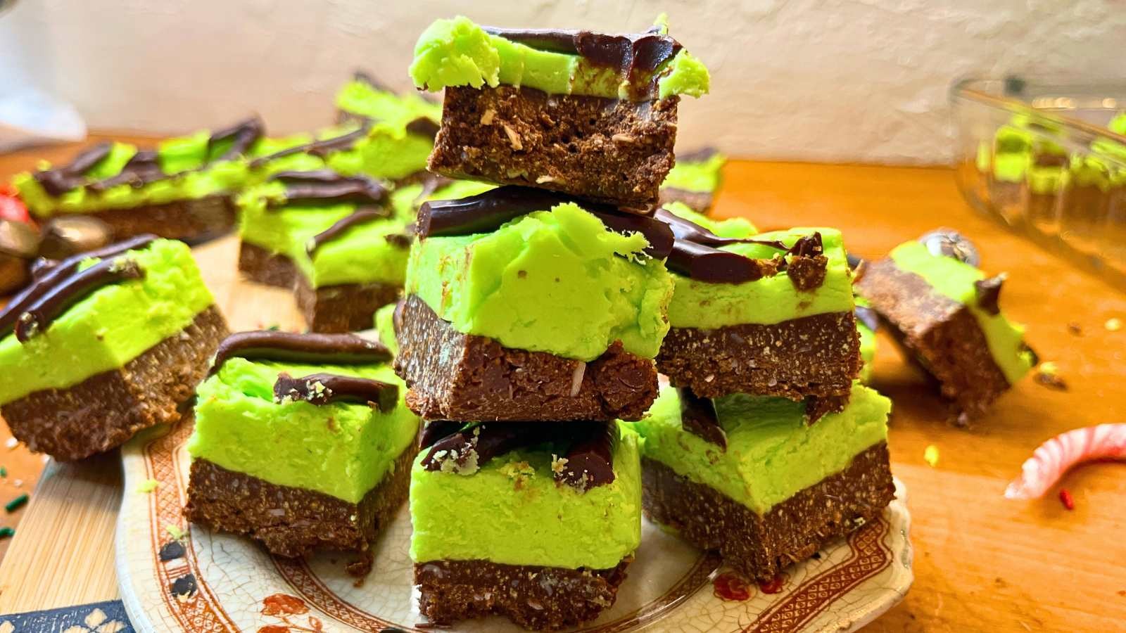 vibrant green and chocolate mint squares on a cooling rack, garnished with fresh mint leaves and chocolate shavings, natural light