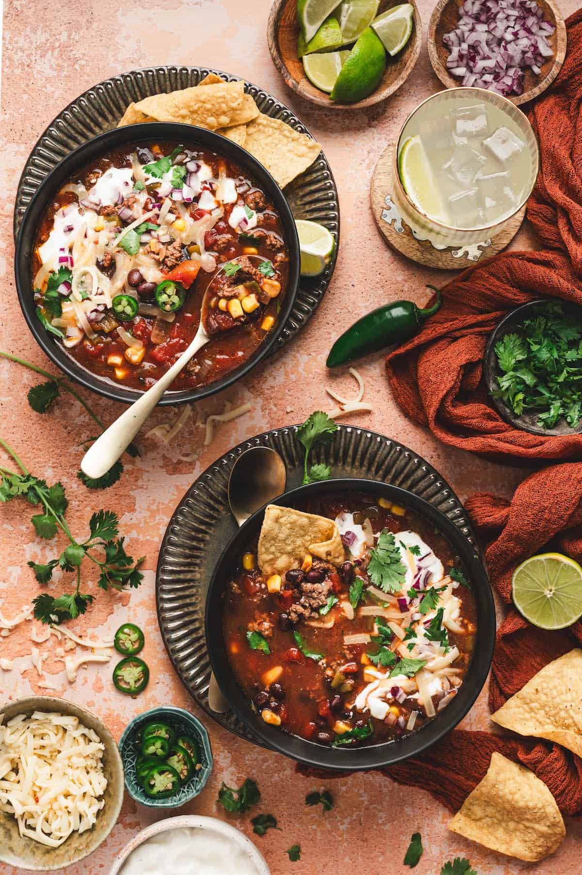 Vibrant bowl of smoky taco beef soup with toppings, cozy kitchen background
