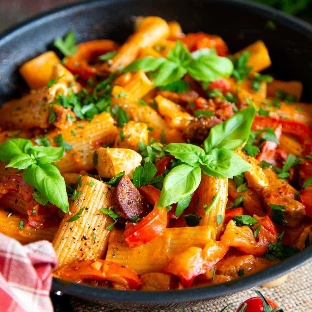 chicken and chorizo pasta with tomato sauce served in a rustic bowl