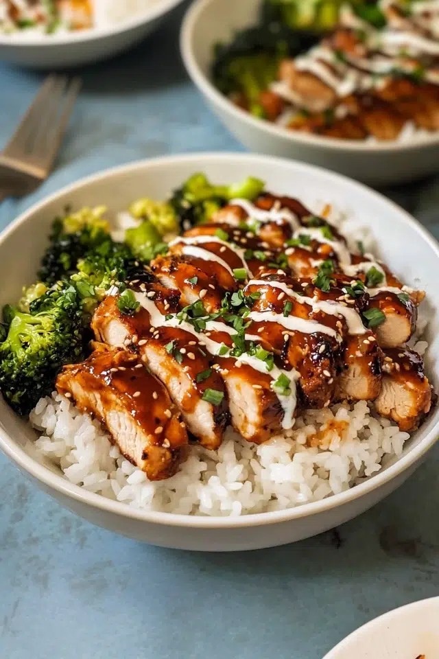 close up of sticky chicken rice bowls with green onions and sesame seeds