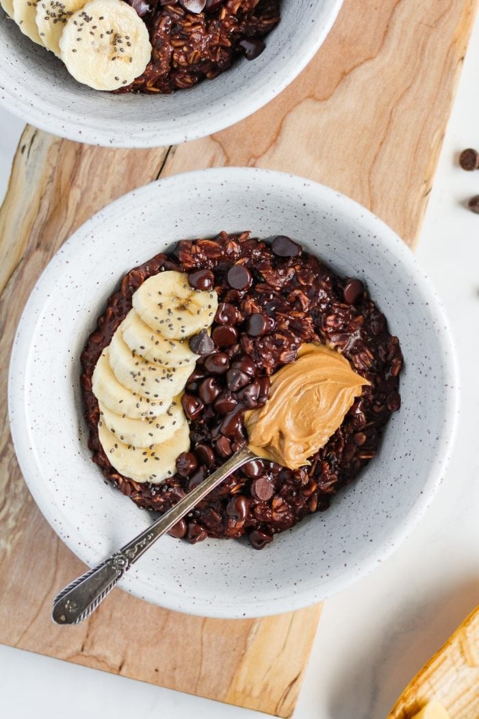 A bowl of creamy oatmeal with hemp milk and chocolate shavings