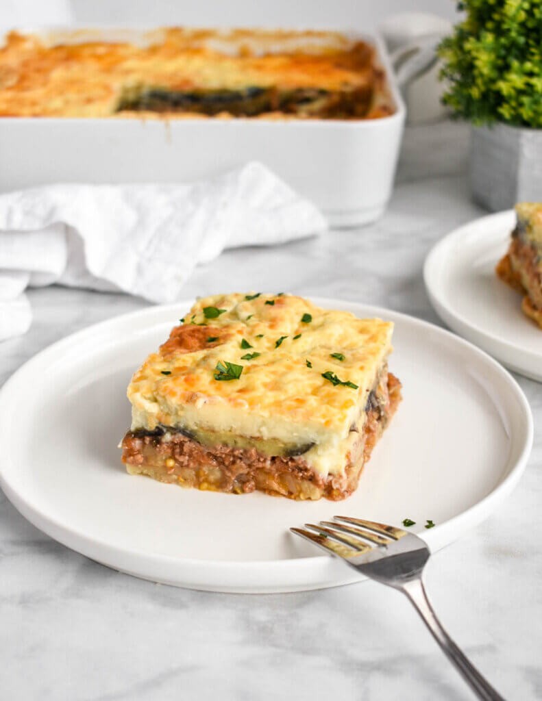 a layered moussaka dish with fresh herbs on top