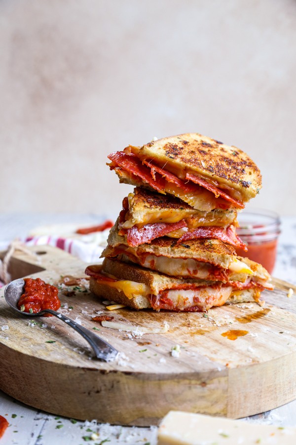 Gourmet Pizza Grilled Cheese Sandwich with melted mozzarella and crispy pepperoni, served on a rustic cutting board