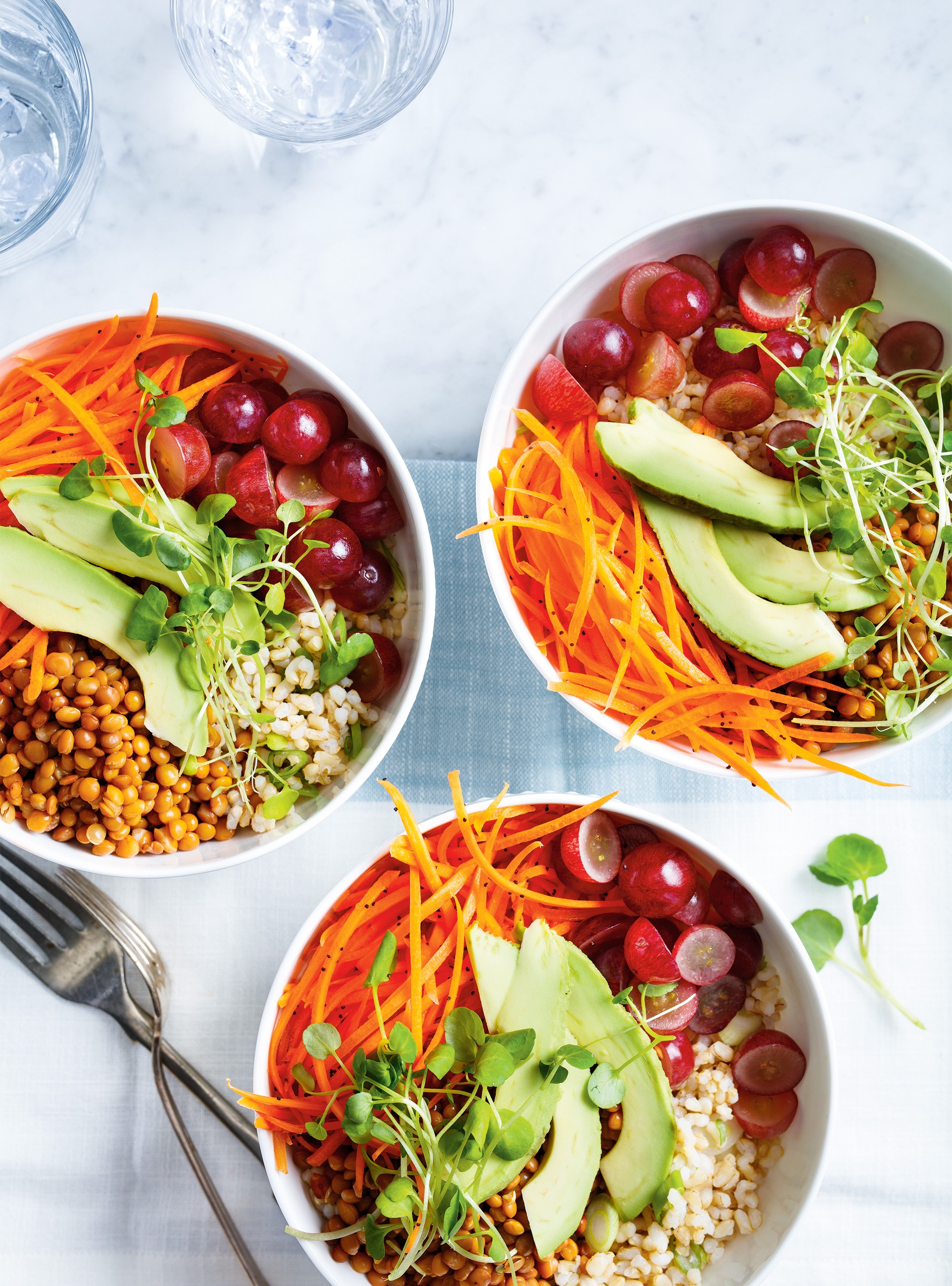 A vibrant and healthy brown rice bowl with lentils and assorted colorful vegetables, garnished with fresh herbs.