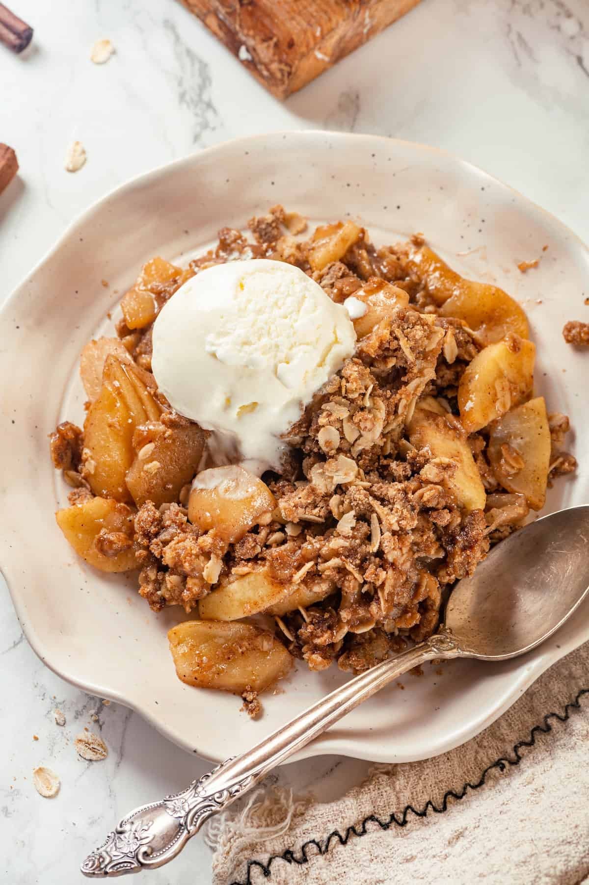 overhead shot of a warm walnut apple crisp with a scoop of vanilla ice cream