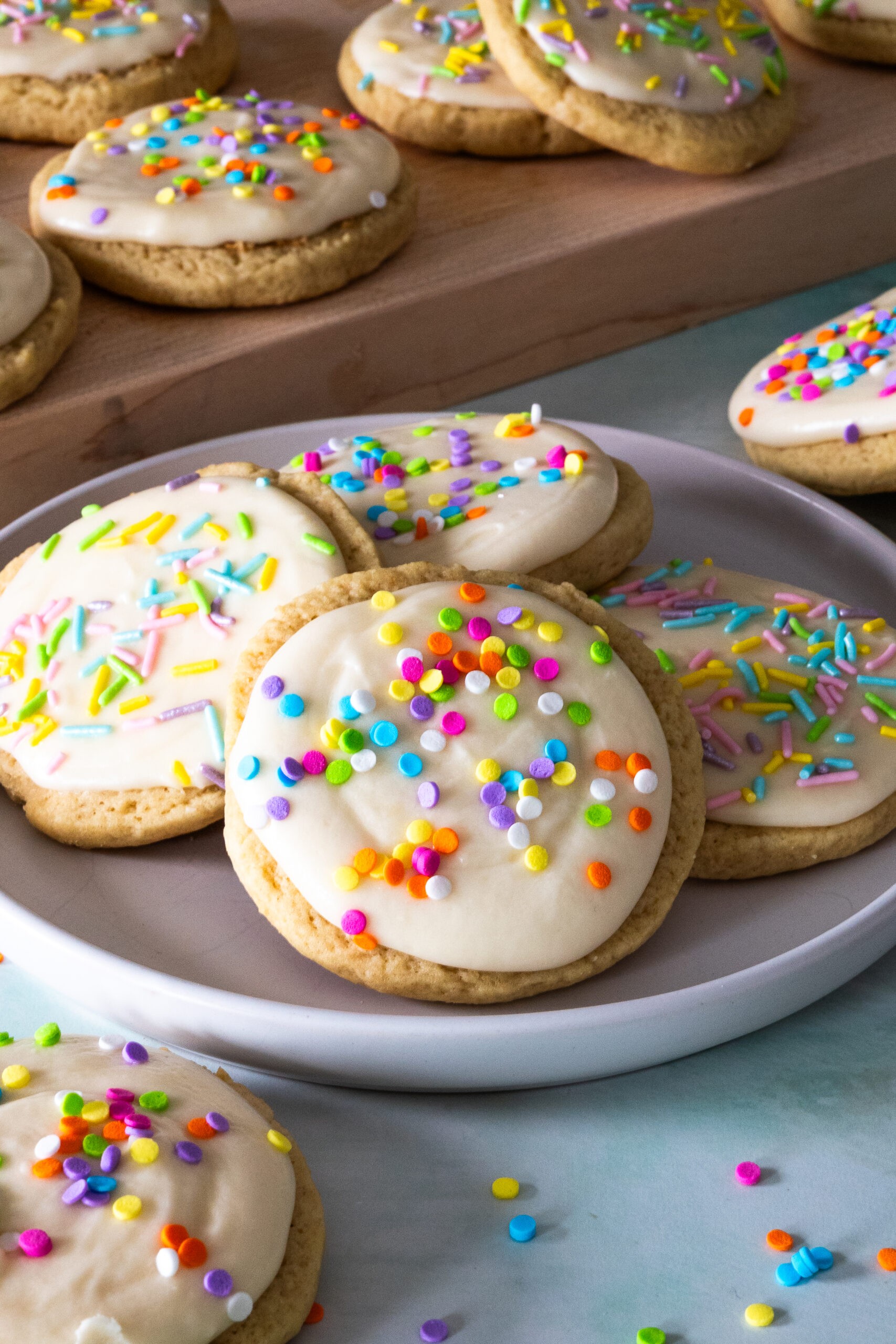 Close-up of freshly baked sprinkle sugar cookies on a cooling rack, vibrant smooth icing