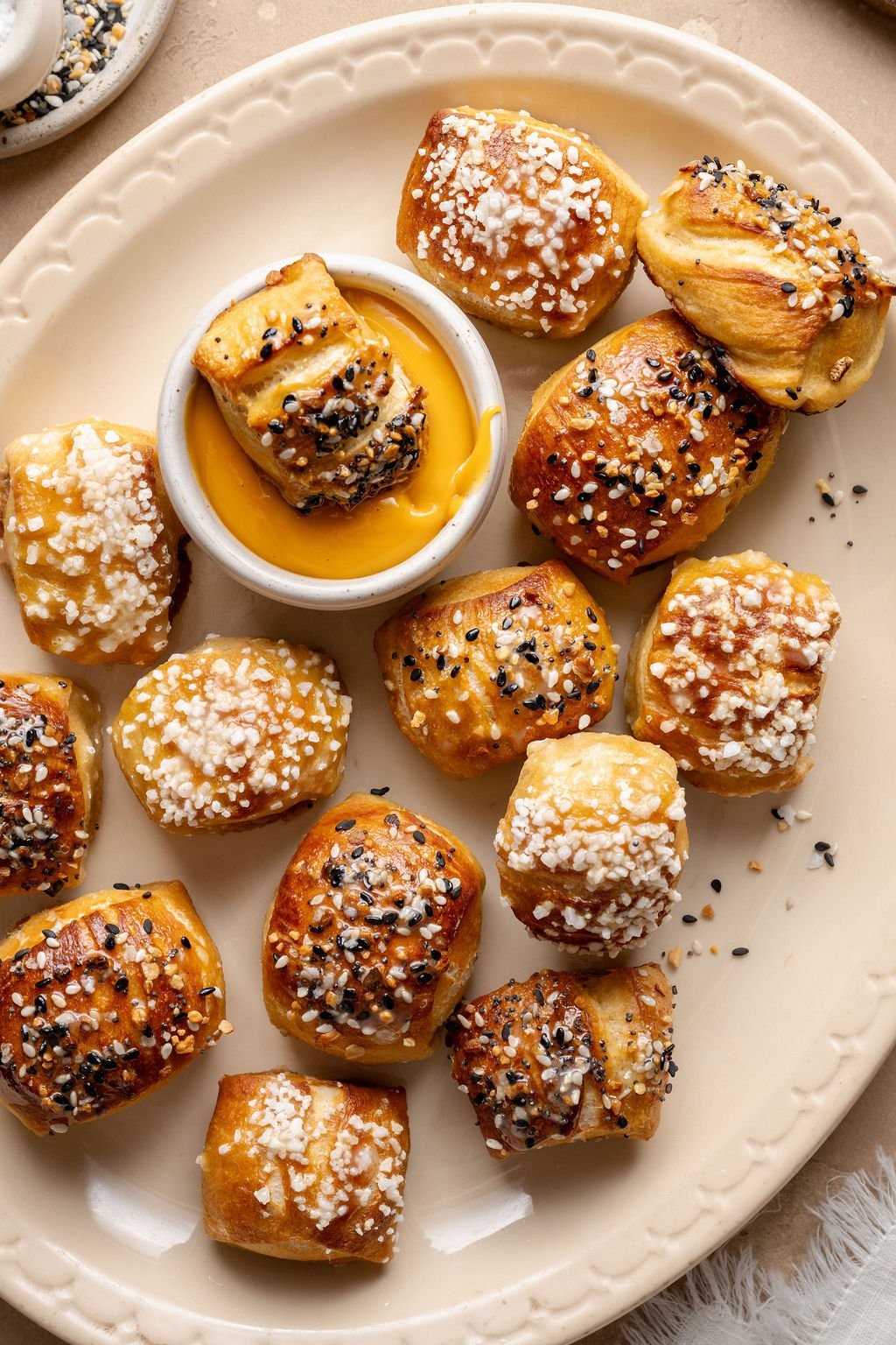 Homemade golden brown salt dough pretzel bites on a baking sheet, sprinkled with coarse salt, warm and inviting