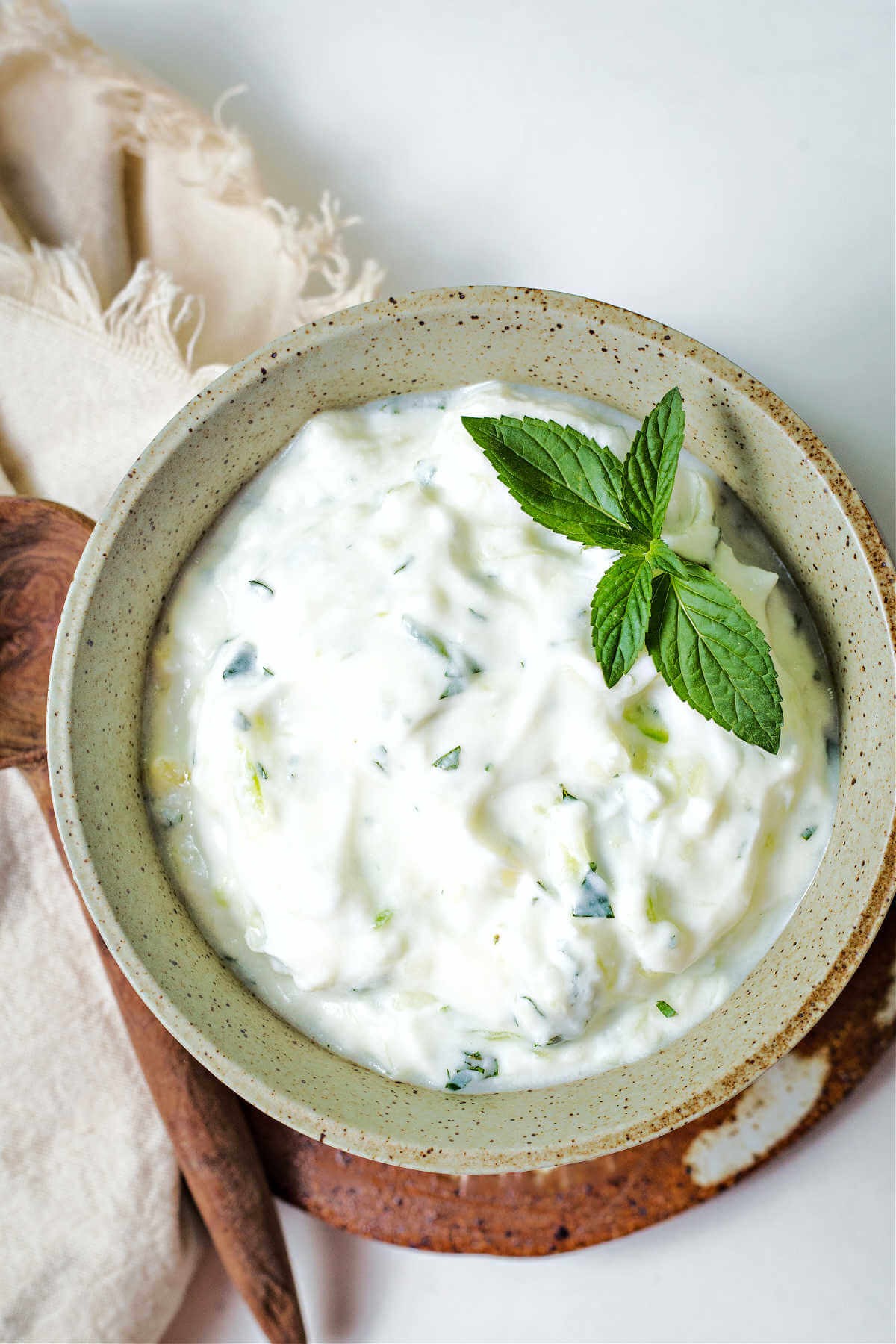 bowl of tzatziki sauce garnished with fresh basil