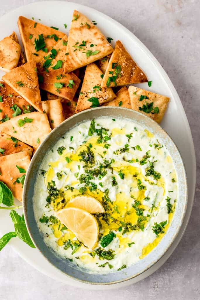 fresh tzatziki sauce in a bowl with cucumbers and pita bread