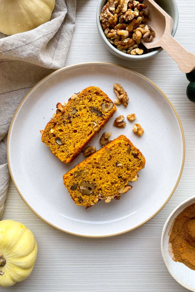 slices of homemade pumpkin bread with nuts and a cup of coffee