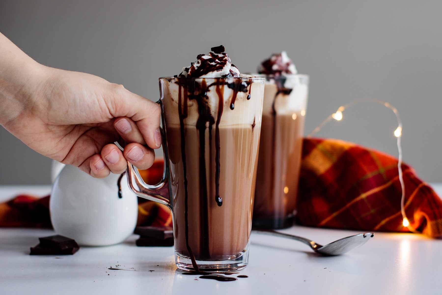 Homemade Starbucks-style chocolate mocha with whipped cream and chocolate drizzle on a cozy table