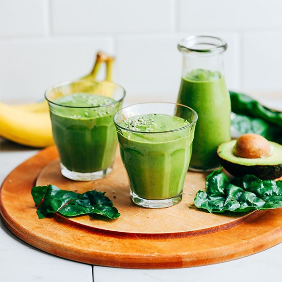 vibrant green vegan smoothie with avocado and spinach