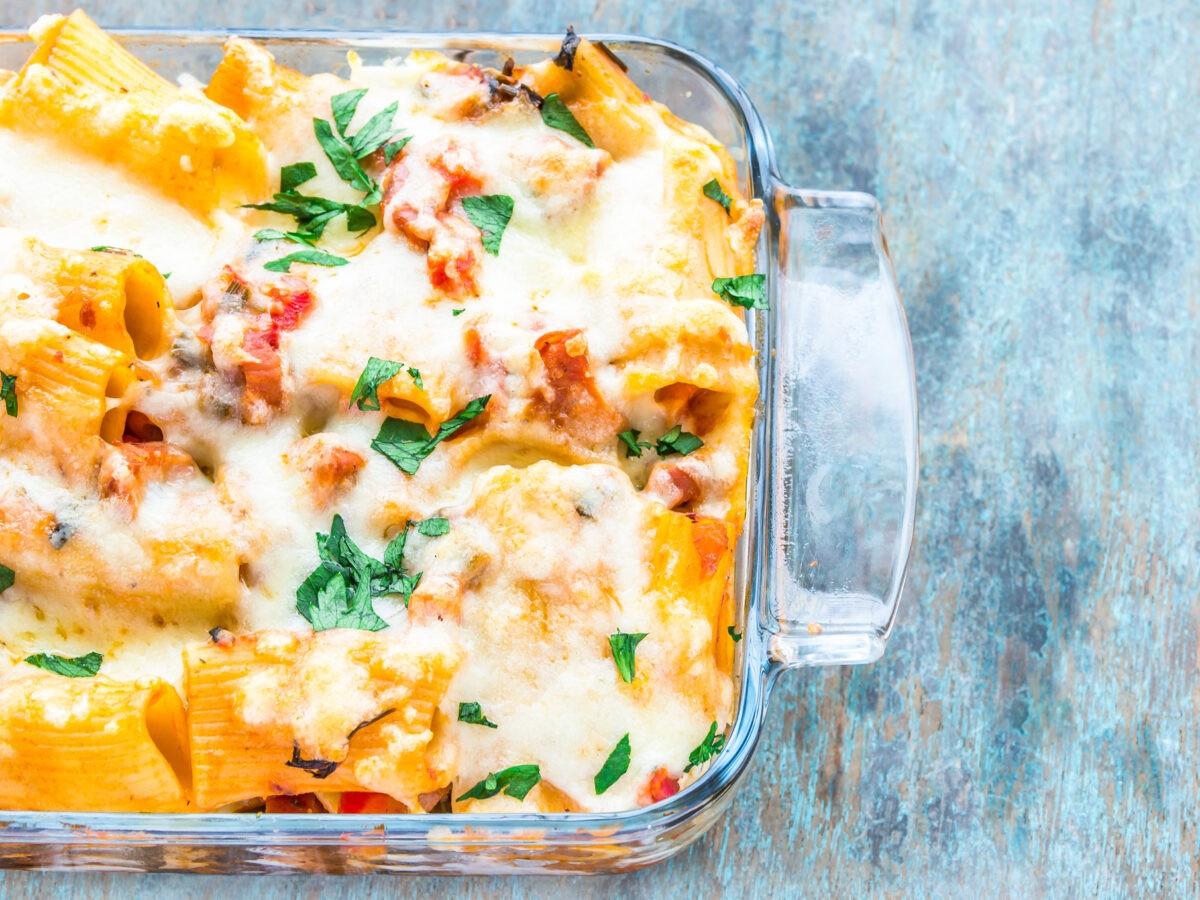 baking dish of golden cheesy baked ziti fresh from oven with steam rising