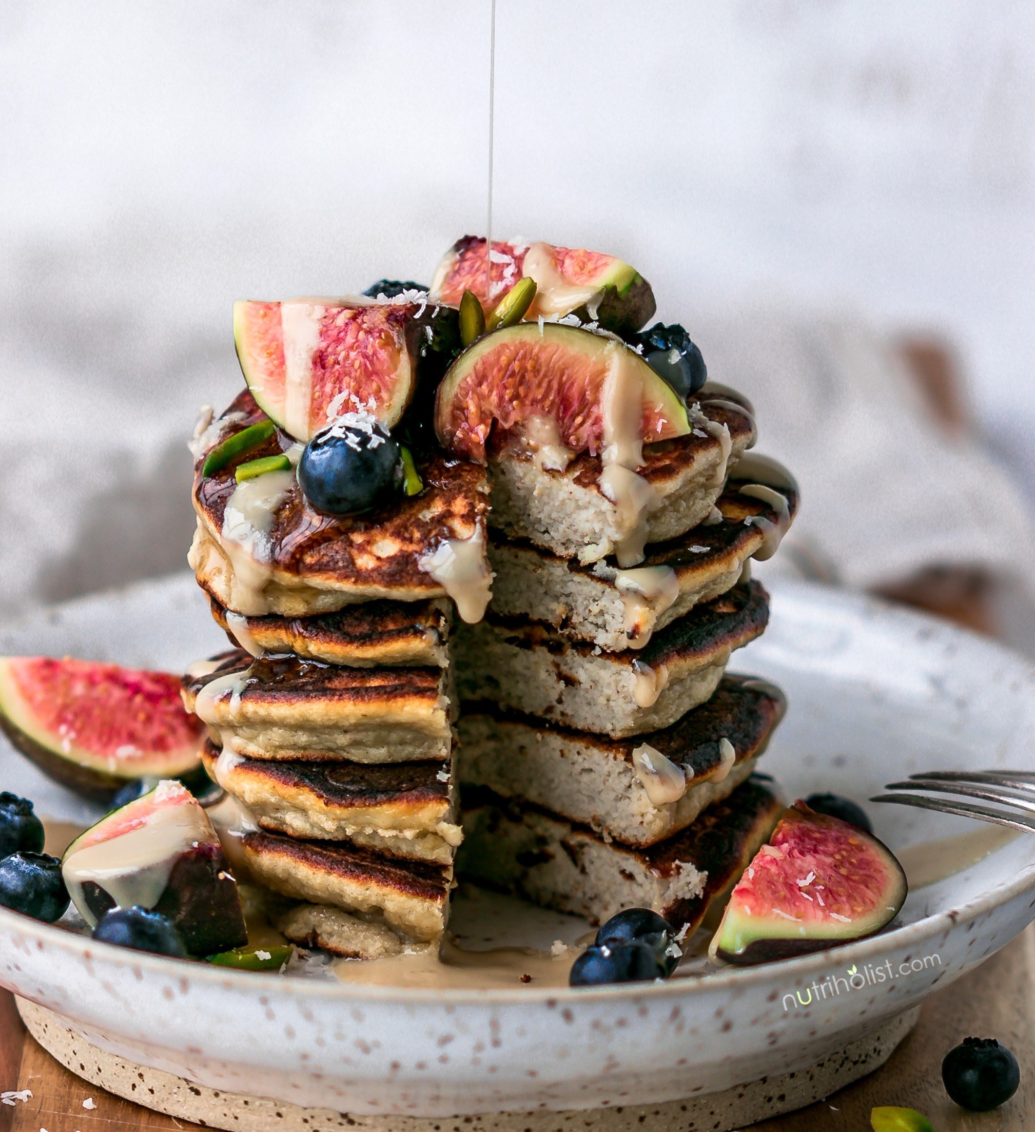 paleo breakfast with coconut flour pancakes topped with fresh berries and nuts
