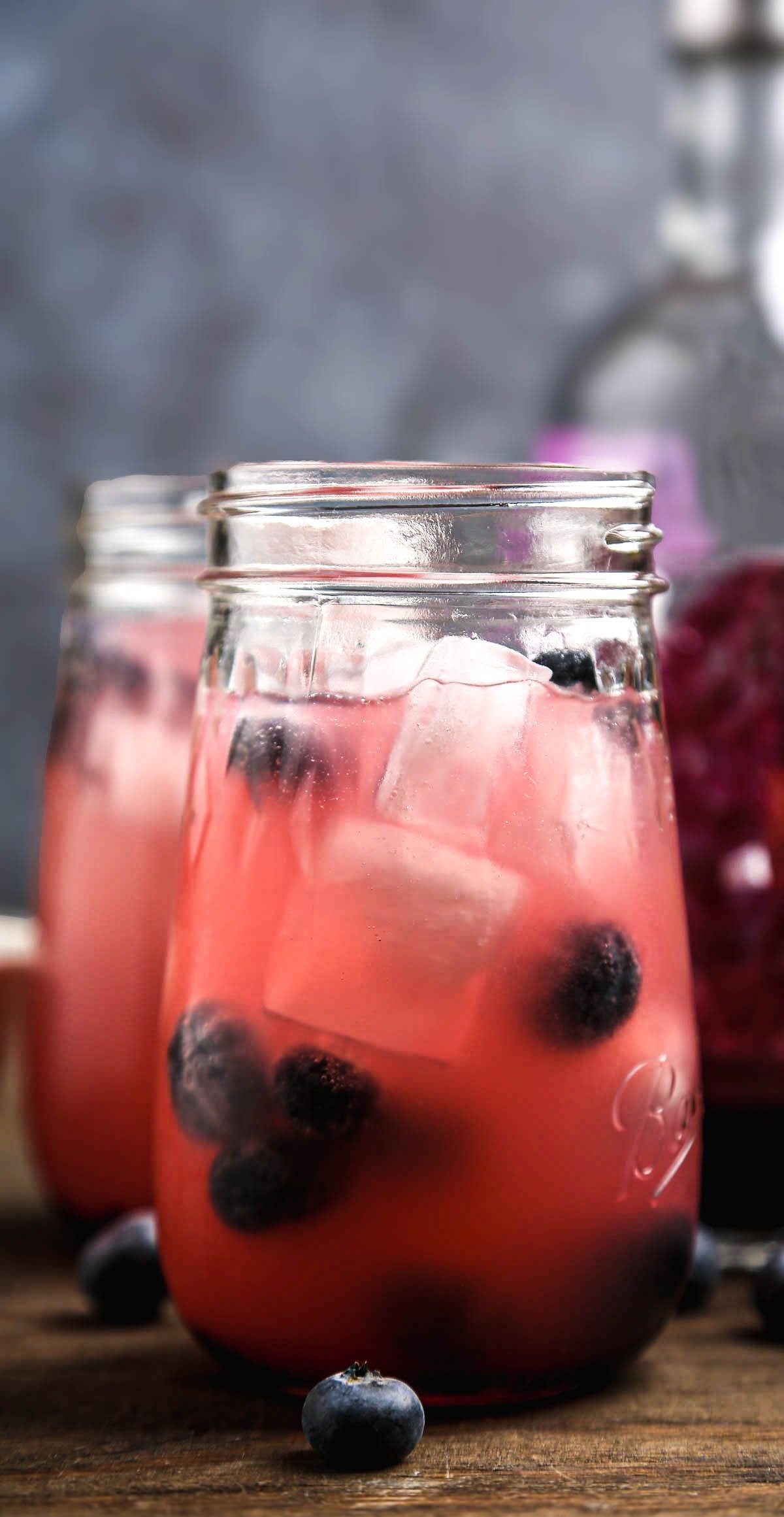 blended kombucha berry drink in a glass with ice and berries
