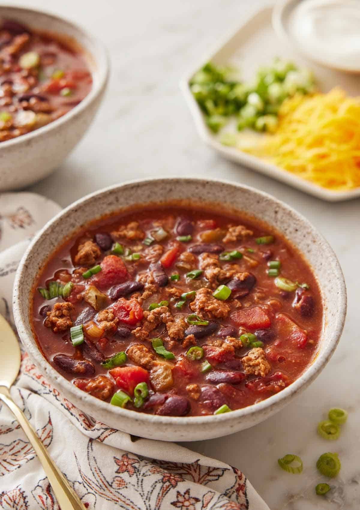 slow cooker chili in bowl with toppings