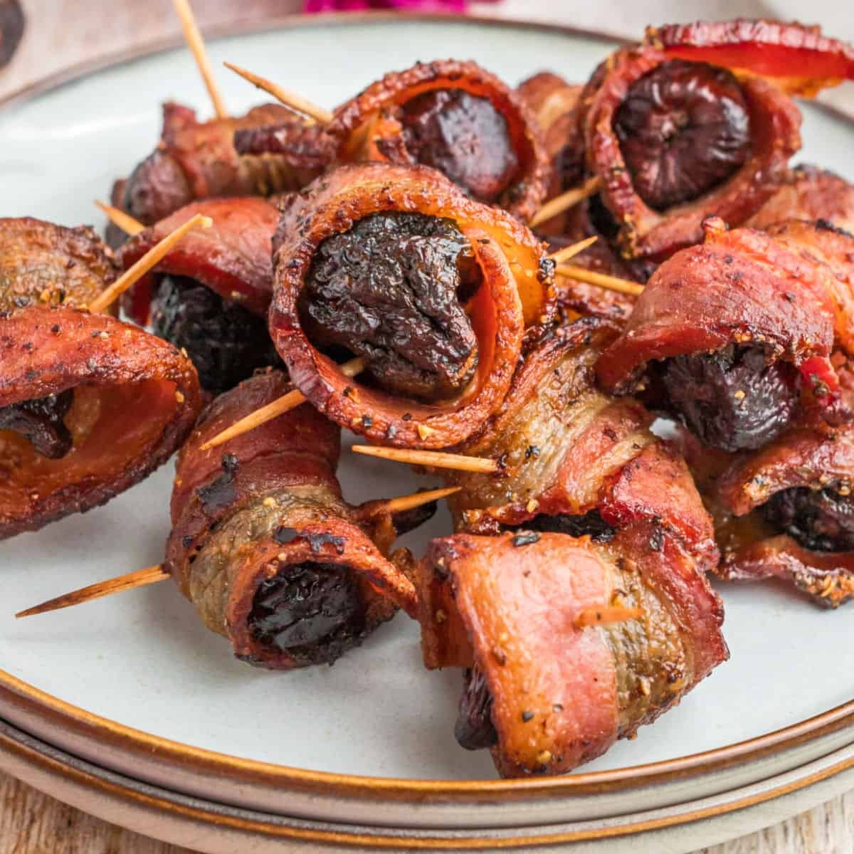 bacon wrapped figs with eggs florentine on a rustic wooden table