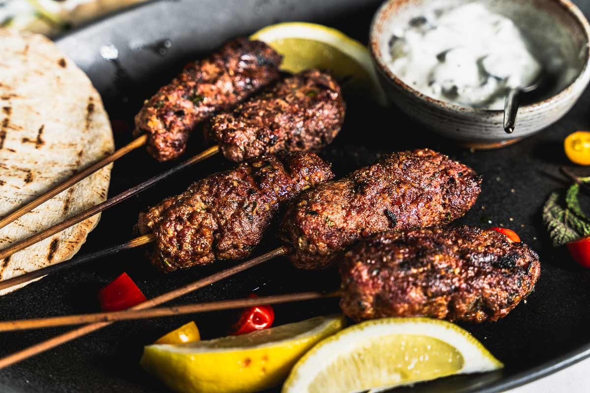 Juicy lamb kebabs with toasted pine nuts on a grill