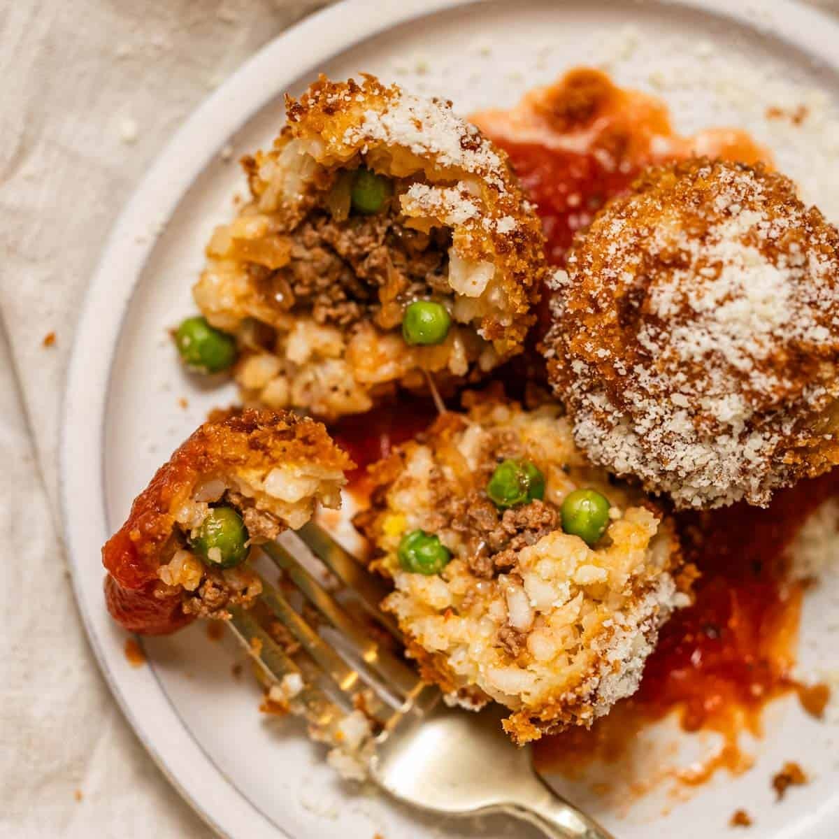 golden brown arancini on a rustic plate, garnished with parsley