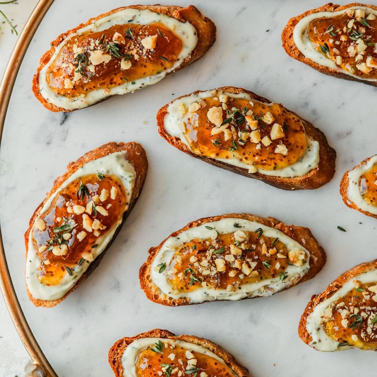 Elegant goat cheese fig crostini with honey drizzle on a rustic platter, surrounded by blurred party setting, close up, warm lighting