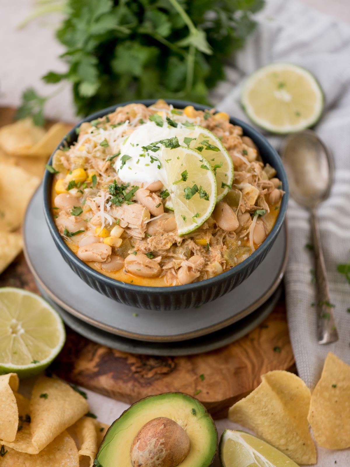 white chicken chili skillet garnished with cilantro and sour cream, close-up, cozy kitchen light
