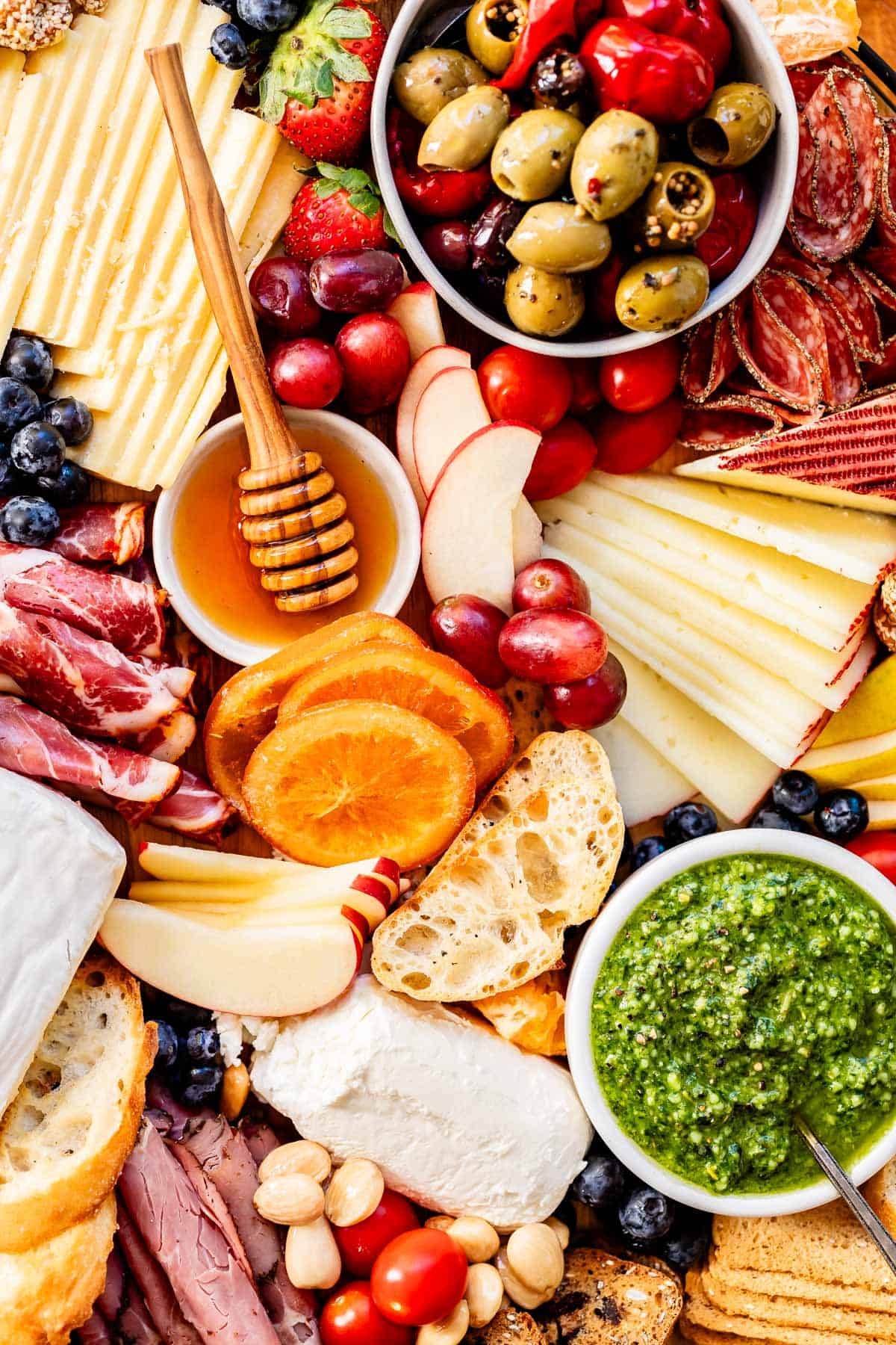 beautifully arranged artisan charcuterie cracker board with cheeses, meats, and fruits, overhead shot