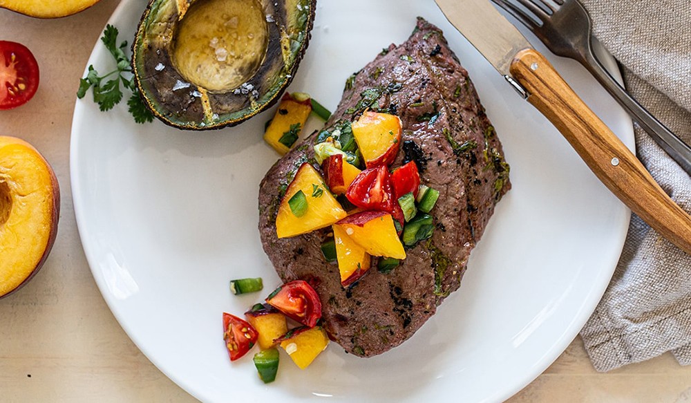 grilled steak topped with fresh peach salsa