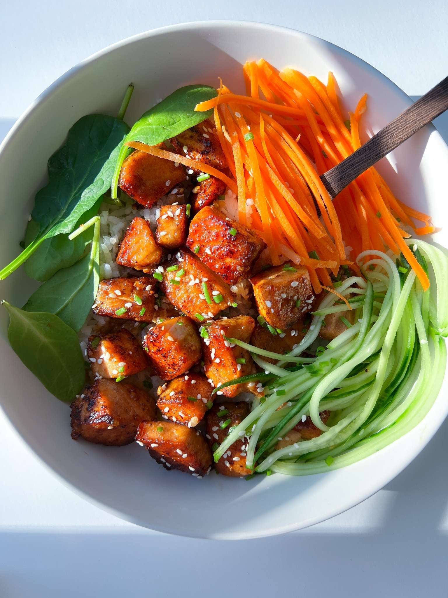A vibrant and healthy Honey Garlic Glazed Salmon Protein Bowl, showcasing the glossy salmon fillet and colorful array of vegetables.