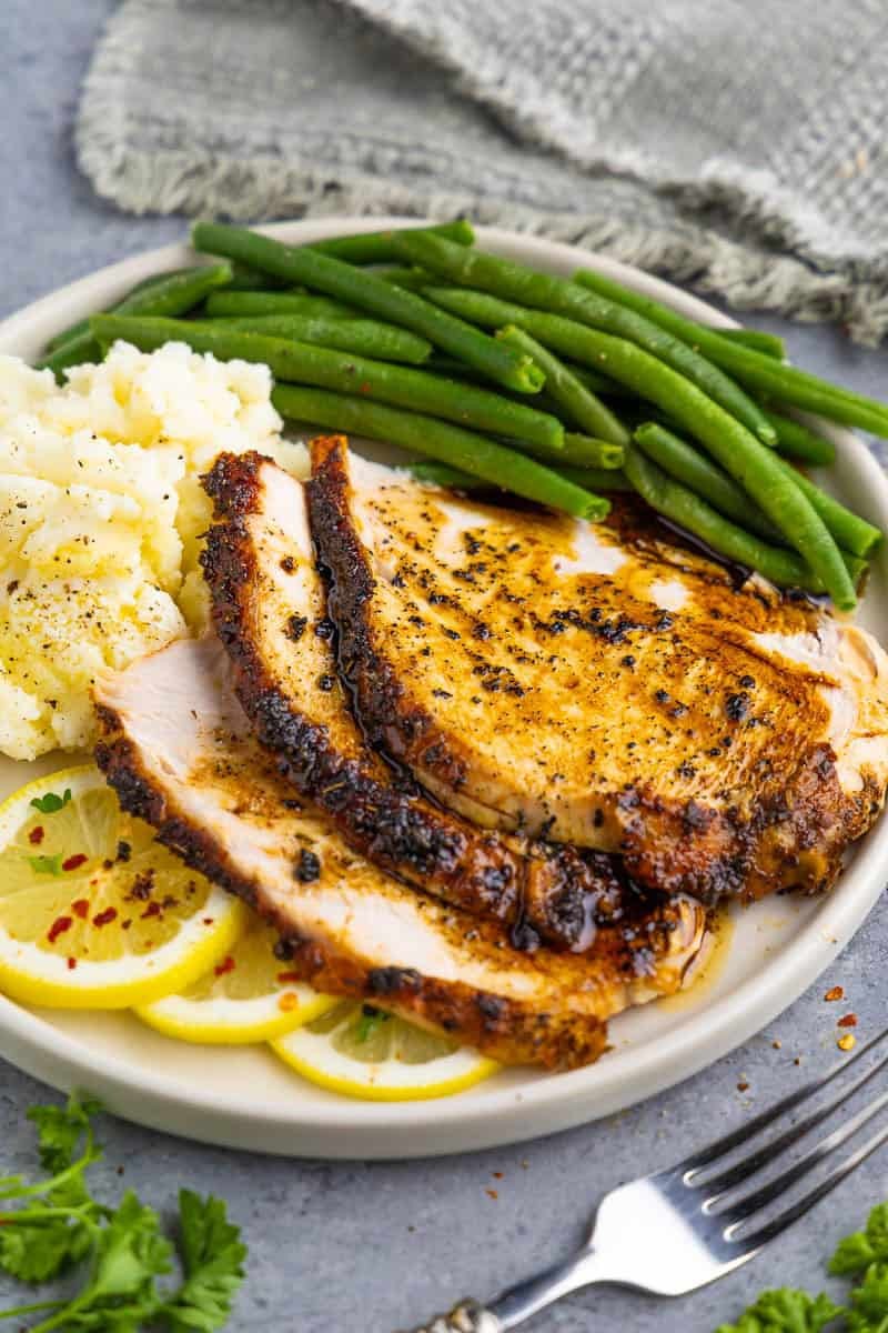 Close-up of perfectly pan-seared turkey breast slices with lemon butter sauce and fresh herbs