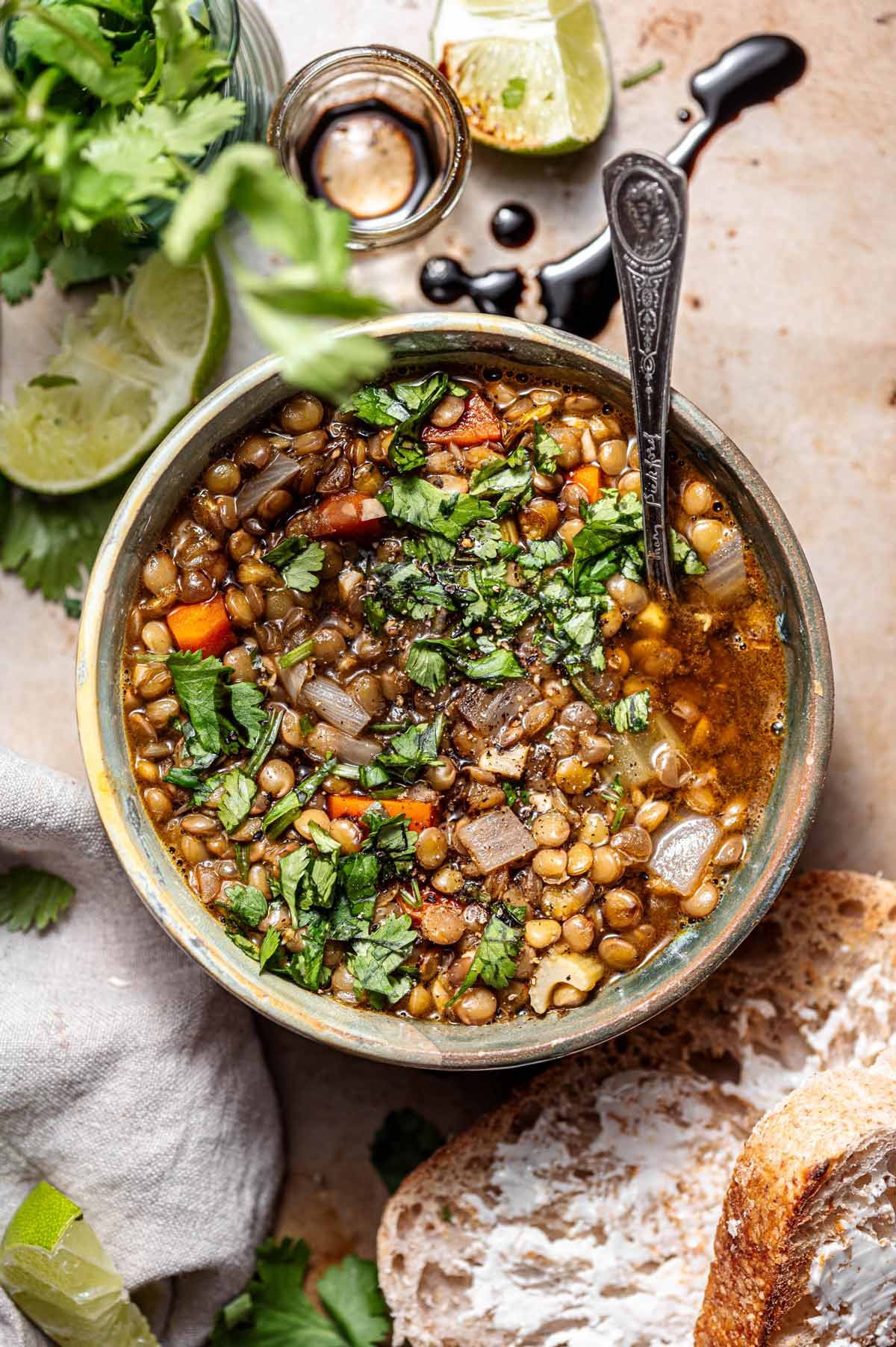 Hearty lentil and vegetable stew simmering in a dutch oven, rich broth, cozy kitchen setting