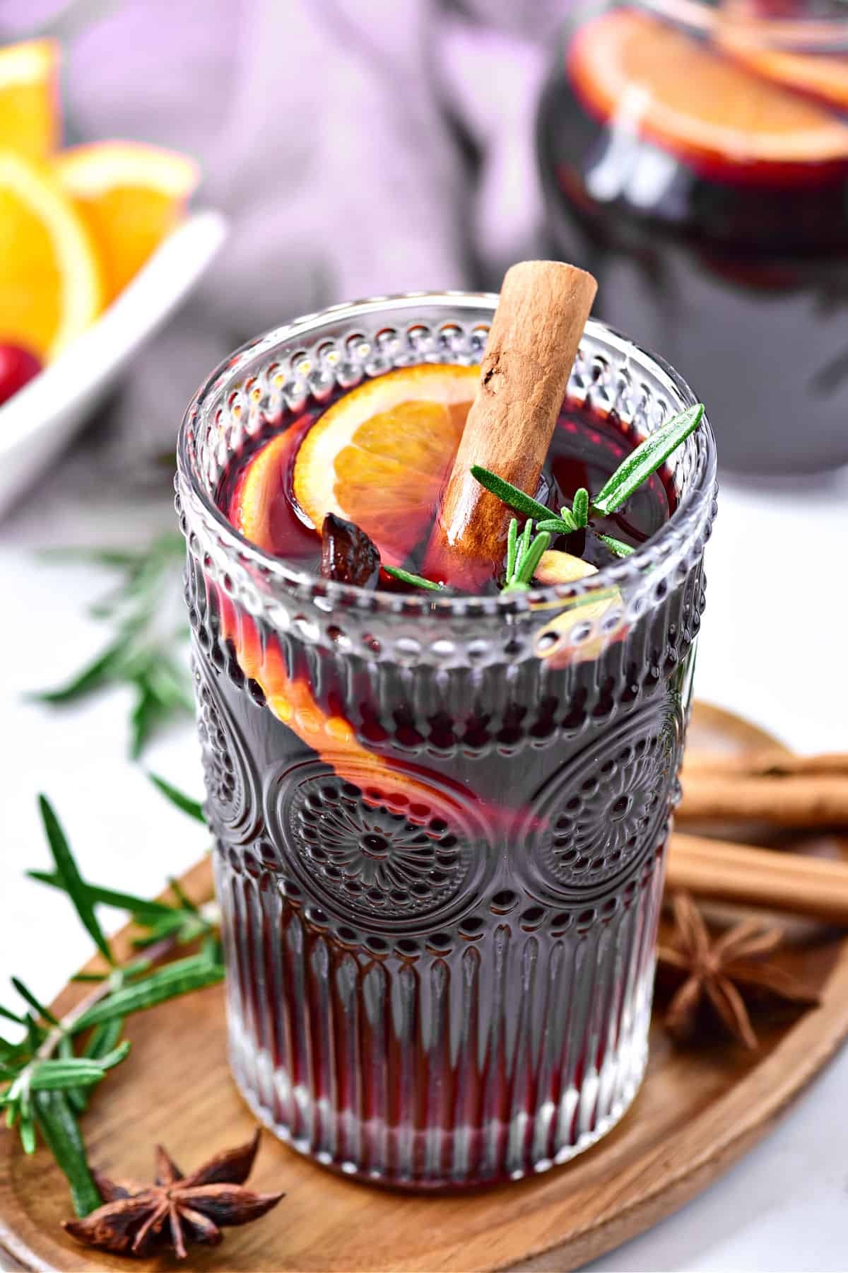 festive orange clove punch with cinnamon sticks and star anise in a glass pitcher