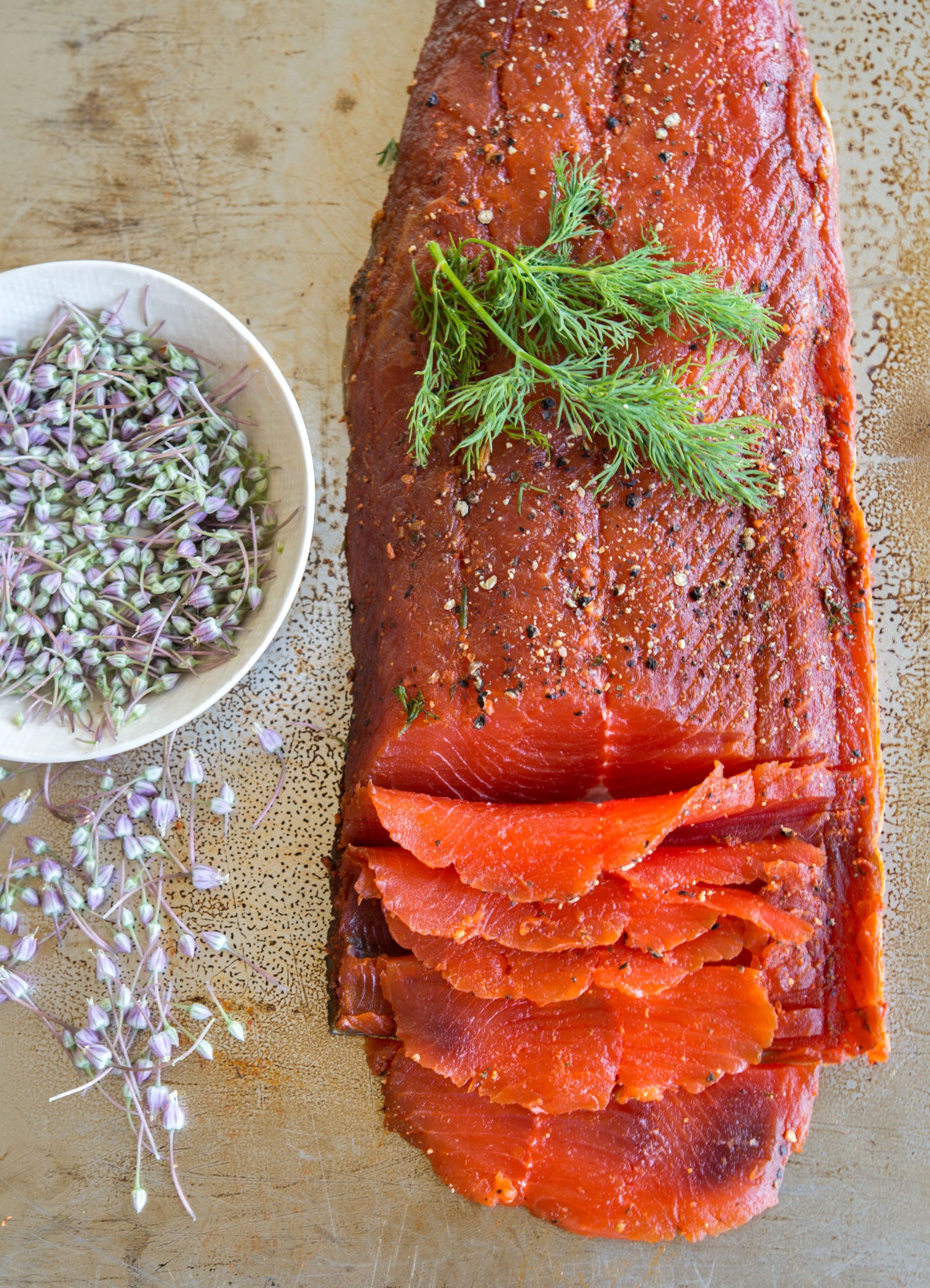 Smoked paprika gravlax with orange segments on a wooden board