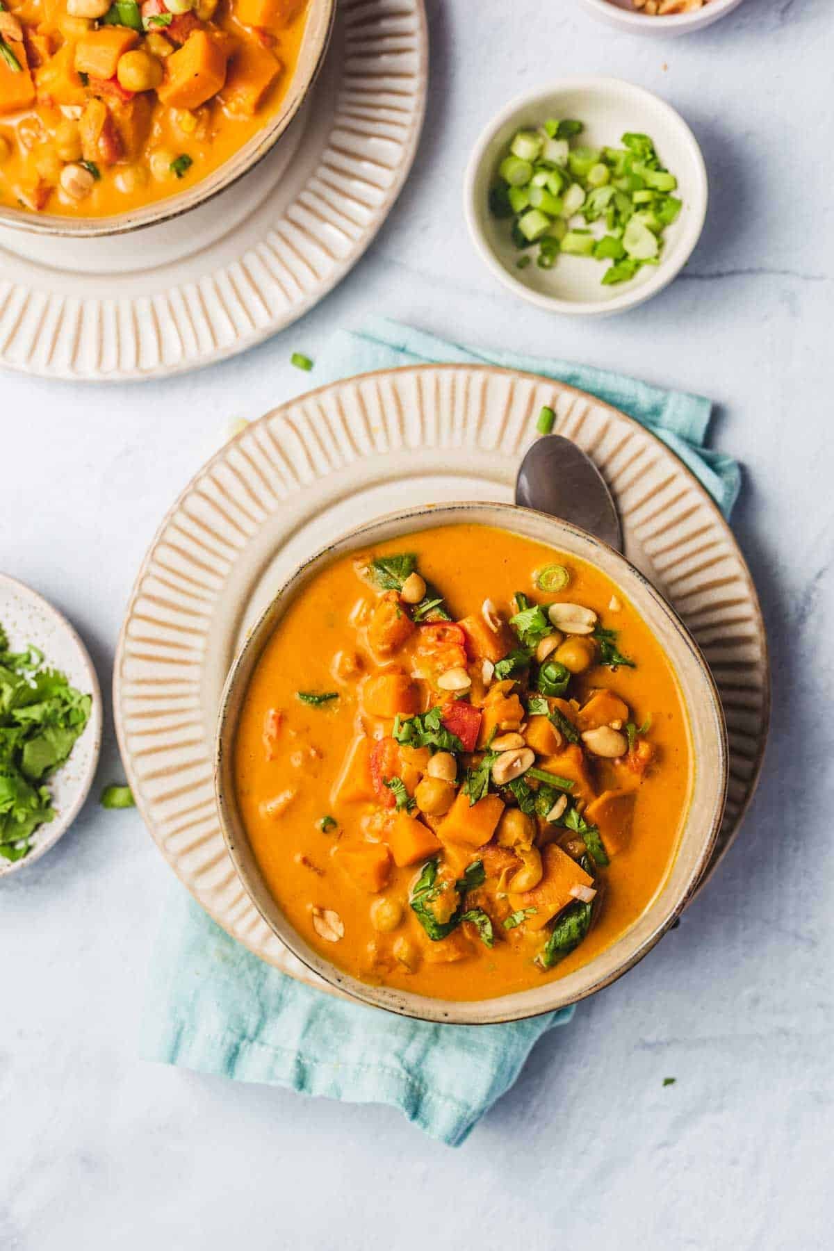 bowl of vegan sweet potato and peanut soup with cilantro garnish