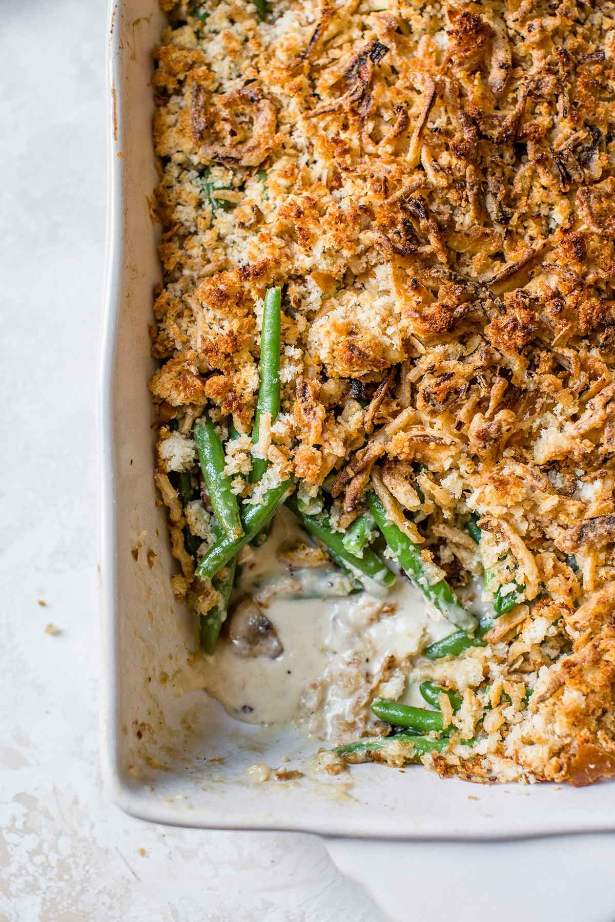 Golden brown cheesy green bean casserole with parmesan crust, rustic setting