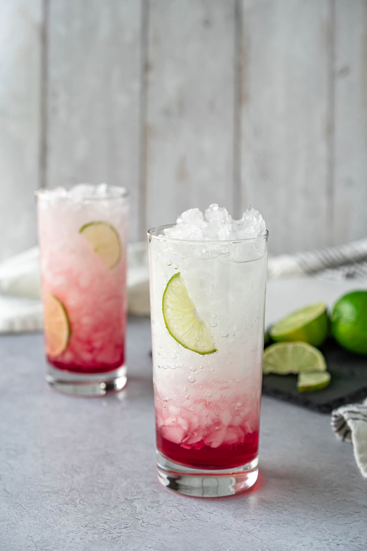 Sparkling Cranberry Lime Lemonade in a mason jar with ice and lime wedges
