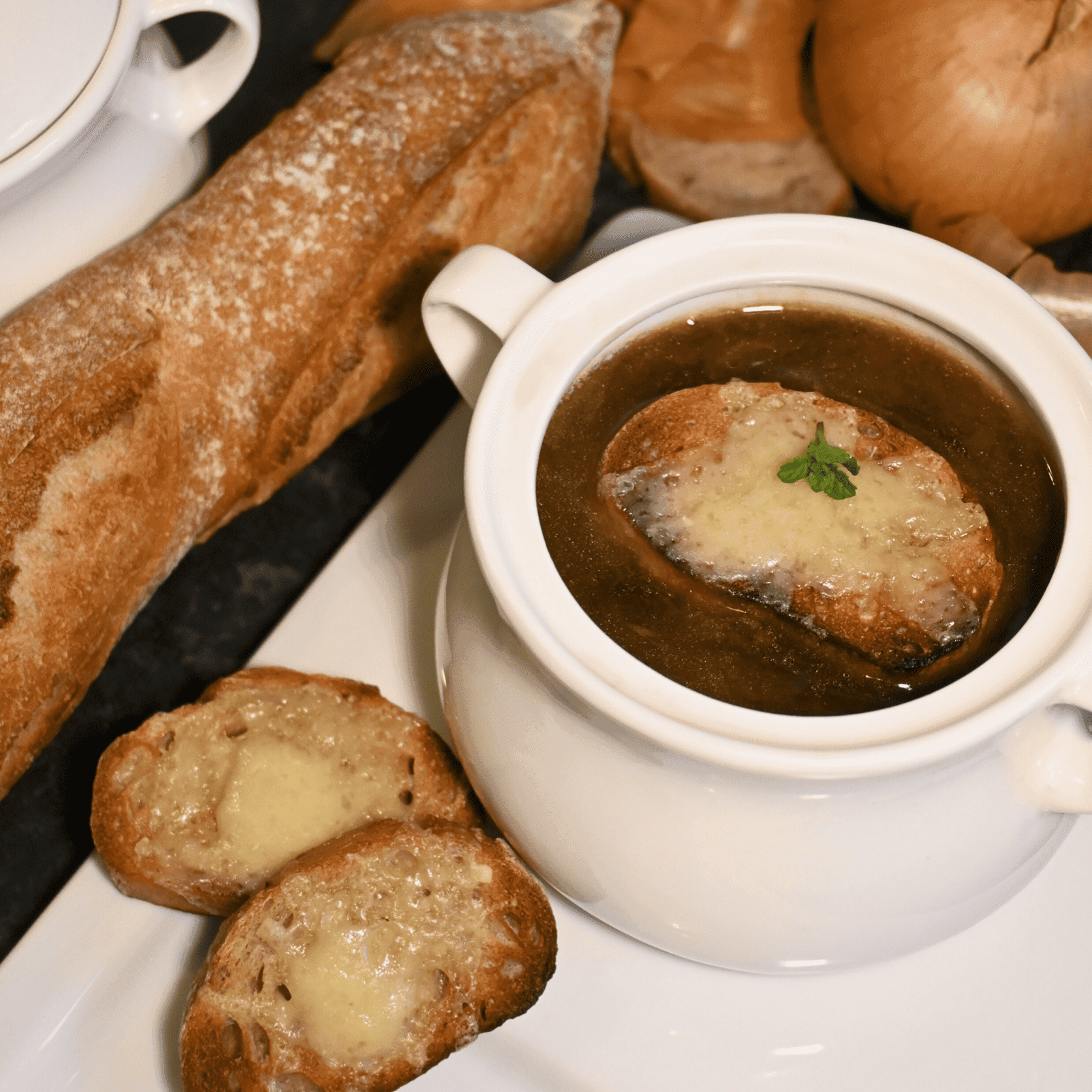 A rustic bowl of French onion soup with a golden brown Gruyere crust, garnished with fresh parsley.